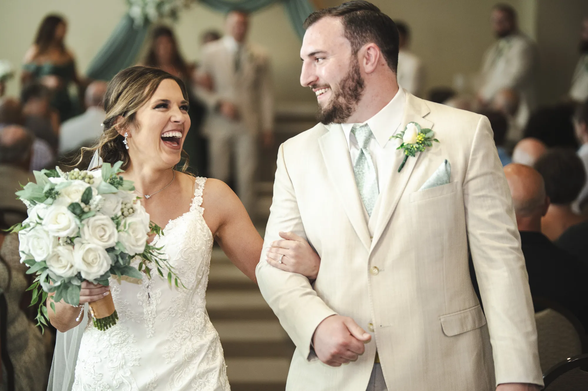 Wedding photography in the Cedar Valley, bride and groom laughing down the aisle