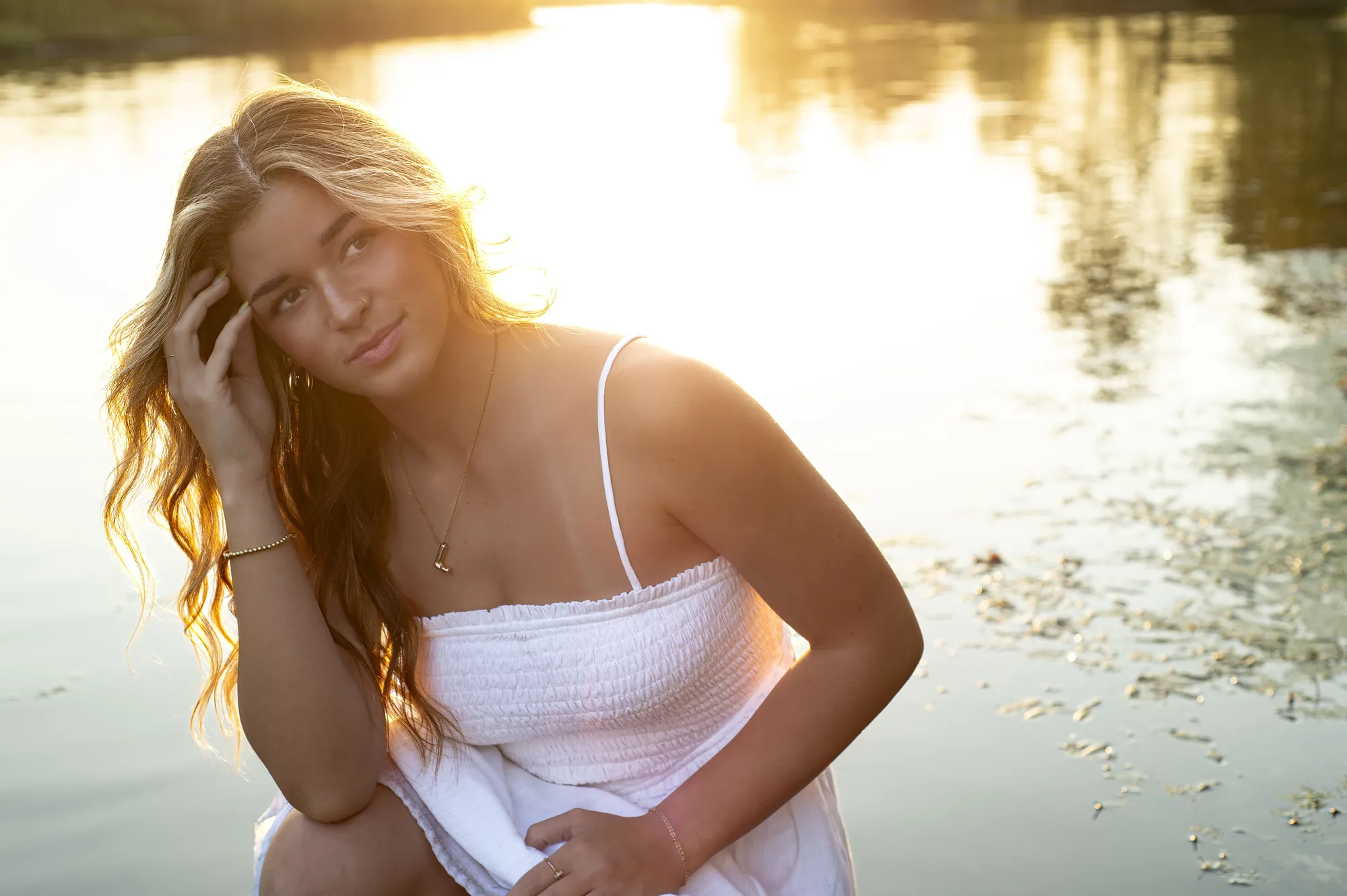 Senior pictures in the Cedar Valley, backlit by the sunset at the water